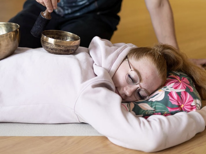 äänimaljatyöpajassa harjoitellaan soittamaan äänimaljoja kehon päällä